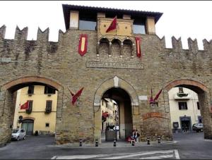 un gran edificio de piedra con un arco delante de él en The Homestay - Arezzo, en Arezzo