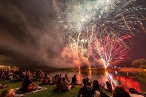 BatesvilleにあるHoliday Inn Express & Suites Batesville by IHGの芝生に座って花火を見ている人々の群れ