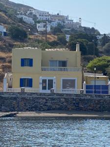 a yellow house on the shore of a body of water at The Condo Palace in Agia Marina in Agia Marina
