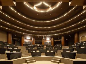 a large lecture hall with lights on the ceiling at Novotel Congress Krasnaya Polyana in Estosadok