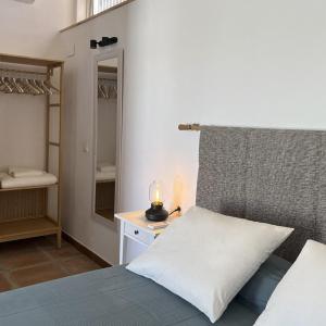 1 dormitorio con 1 cama con lámpara y espejo en El Patio de las Minas, en Aznalcázar