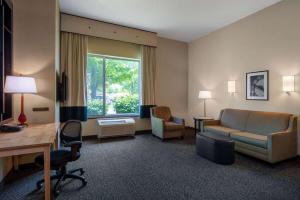 a hotel room with a couch and a chair and a desk at Wyndham Noblesville in Noblesville