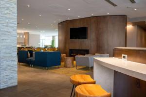 a lobby with a fireplace and a bar with stools at Wyndham Westfield in Westfield