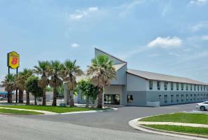 a building with palm trees in front of it at Super 8 by Wyndham New Braunfels I-35 in New Braunfels