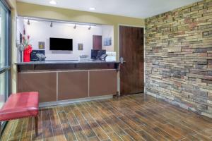 a lobby with a reception desk and a brick wall at Super 8 by Wyndham New Braunfels I-35 in New Braunfels