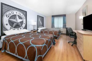 a hotel room with two beds and a flat screen tv at Super 8 by Wyndham New Braunfels I-35 in New Braunfels