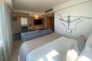 a bedroom with a large bed and a couch at Tryp by Wyndham Brasília Nações in Brasilia