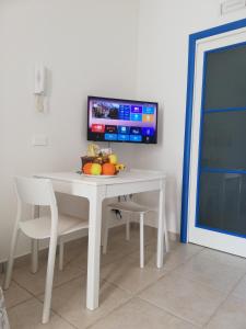 una mesa blanca con un bol de fruta en ella en Le Stelle di Orione, en Fontane Bianche