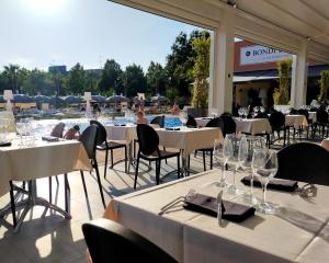 a restaurant with tables and chairs and a pool at The Sydney Hotel in Bologna