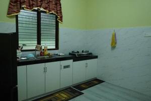 a kitchen with a sink and a window at ZZ Homestay in Bukit Payong