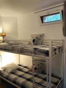 two bunk beds in a room with a window at Appartement 3 pièces et jardin in Collioure