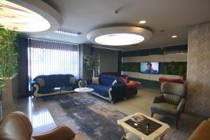 a living room with couches and a flat screen tv at Anatolia Park Hotel in Kayseri