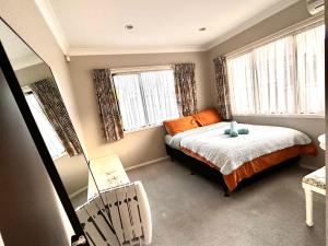 een kleine slaapkamer met een bed en 2 ramen bij West Harbour White House (西港白宫） in Auckland