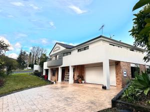 een wit bakstenen huis met een garage bij West Harbour White House (西港白宫） in Auckland