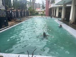een groep mensen die zwemmen in een zwembad bij Pinebreeze Holiday Resort in Nyali