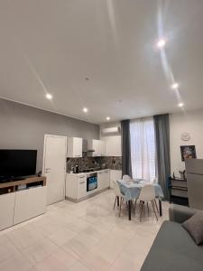 a kitchen and living room with a table and a kitchen and a dining room at Casa di Mimì in Gela
