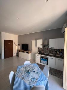 a living room with a table and a kitchen at Casa di Mimì in Gela +22 photos