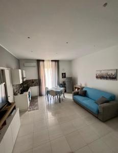 a living room with a blue couch and a table at Casa di Mimì in Gela