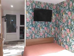 a bedroom with a bed and a tv on a wall at Fallburn Hideaway in Knockanully