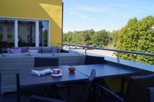 einen blauen Tisch und Stühle auf einem Balkon mit einem Sofa in der Unterkunft Hotel-Restaurant Stand'Inn in Foetz
