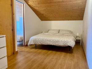 a bedroom with a bed and a wooden ceiling at Appartamento sulle piste Folgarida in Folgarida