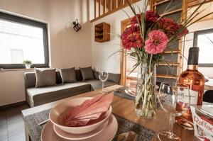a living room with a table with a vase of flowers at Domki Pod Dębem in Sulęczyno