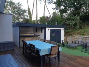 een patio in de achtertuin met een tafel en een barbecue bij Jolie maison moderne et sereine à Labenne in Labenne