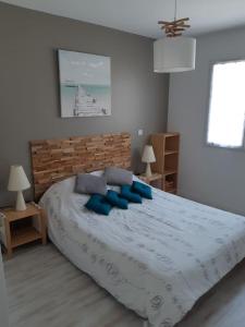 een slaapkamer met een groot bed met blauwe kussens bij Jolie maison moderne et sereine à Labenne in Labenne