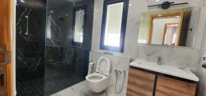 a bathroom with a toilet and a sink and a shower at Villa fadhloun 2 in Awlād ‘Umar