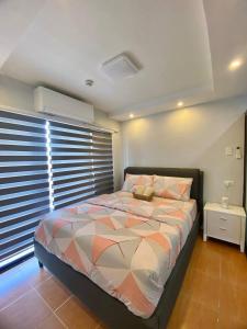 - une chambre avec un grand lit et une fenêtre dans l'établissement Staycation Condo at One Oasis CDO, à Cagayán de Oro