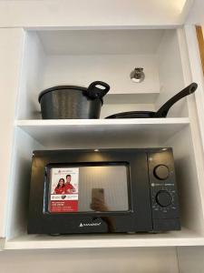 a microwave oven with a pot on top of it at Staycation Condo at One Oasis CDO in Cagayan de Oro +7 photos