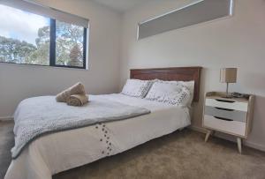 a bedroom with a large bed and a window at Henderson New House (瀚德森新居） in Auckland