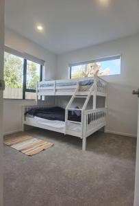 1 Schlafzimmer mit 2 Etagenbetten und einem Fenster in der Unterkunft Henderson New House (瀚德森新居） in Auckland