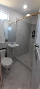 a white bathroom with a toilet and a sink at Casa Apartamento Campestre en las Faldas del Tayta Imbabura in San Juan de Ilumán