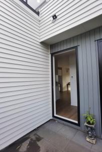 eine Glasschiebetür an der Seite eines Hauses in der Unterkunft Henderson New House (瀚德森新居） in Auckland