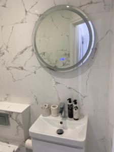 bagno bianco con lavandino e specchio di Guesthouse in Central Fleet a Fleet