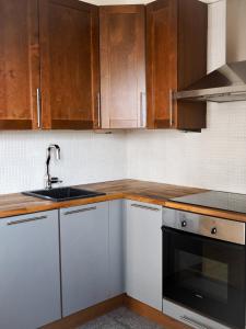 a kitchen with wooden cabinets and a sink at Rautatienkatu 13 B in Lahti