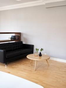 a living room with a black couch and a table at Rautatienkatu 13 B in Lahti