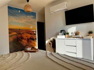 1 dormitorio con 1 cama y TV grande en la pared en Bałtyckie Klimaty en Stegna