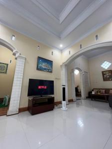 una gran sala de estar con TV en el centro en Guesthouse Eldys, en Gondowulung