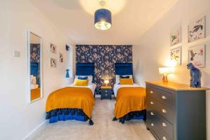 a bedroom with two beds and a dresser at Something a little bit special! in Llandudno