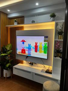 a television with colorful vases on it in a living room at Staycation Condo at One Oasis CDO in Cagayan de Oro