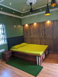 a bed in a room with a green wall at Pravuprasad Homestay in Bhubaneshwar