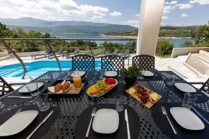 una mesa con comida y vistas a la piscina en Escape on Lake - Holiday House en Vrlika