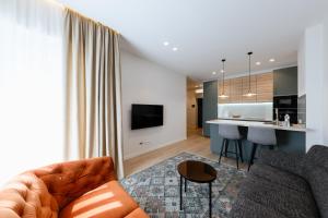 a living room with a couch and a kitchen at ММ GROUP APARTMENT in Uzhhorod