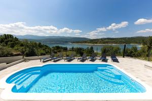 a swimming pool with a view of a lake at Escape on Lake - Holiday House in Vrlika