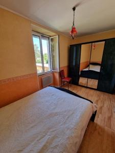 1 dormitorio con cama blanca y ventana en Appartement silencieux avec une belle vue . en Morez
