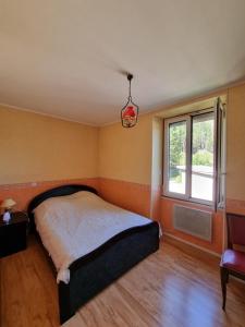 1 dormitorio con cama y ventana en Appartement silencieux avec une belle vue . en Morez