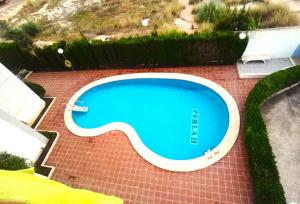 een uitzicht over een zwembad op een bakstenen patio bij Piso en Gandía con piscina in Playa de Gandia