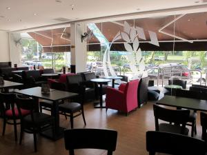 a restaurant with tables and chairs and a large window at Badi'ah Hotel in Bandar Seri Begawan